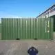A green shipping container is displayed with a blue sky backdrop and text overlaying it.