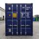 A blue shipping container with labels, details, and caution signs, set against a warehouse backdrop.