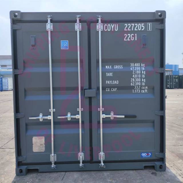 A shipping container with weight specifications and branding in the background. Industrial setting.